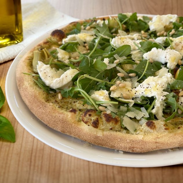 Pizza végétarienne avec base pesto, mozzarella di Bufala, artichauts, roquette et pignons – création du mois Gino & Giulia