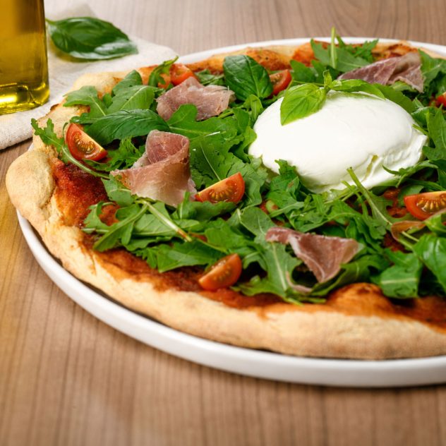 Pizza Bufala avec mozzarella di bufala, jambon de Parme, roquette, tomates cerises et basilic chez Gino & Giulia.