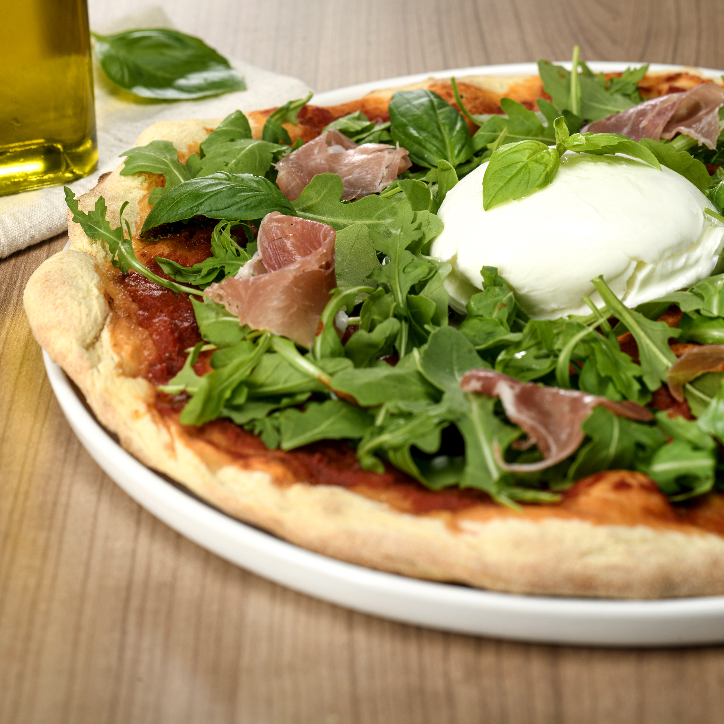 Pizza Bufala avec mozzarella di Bufala, jambon de Parme, roquette, basilic et huile d’olive – pizza italienne à emporter ou en livraison