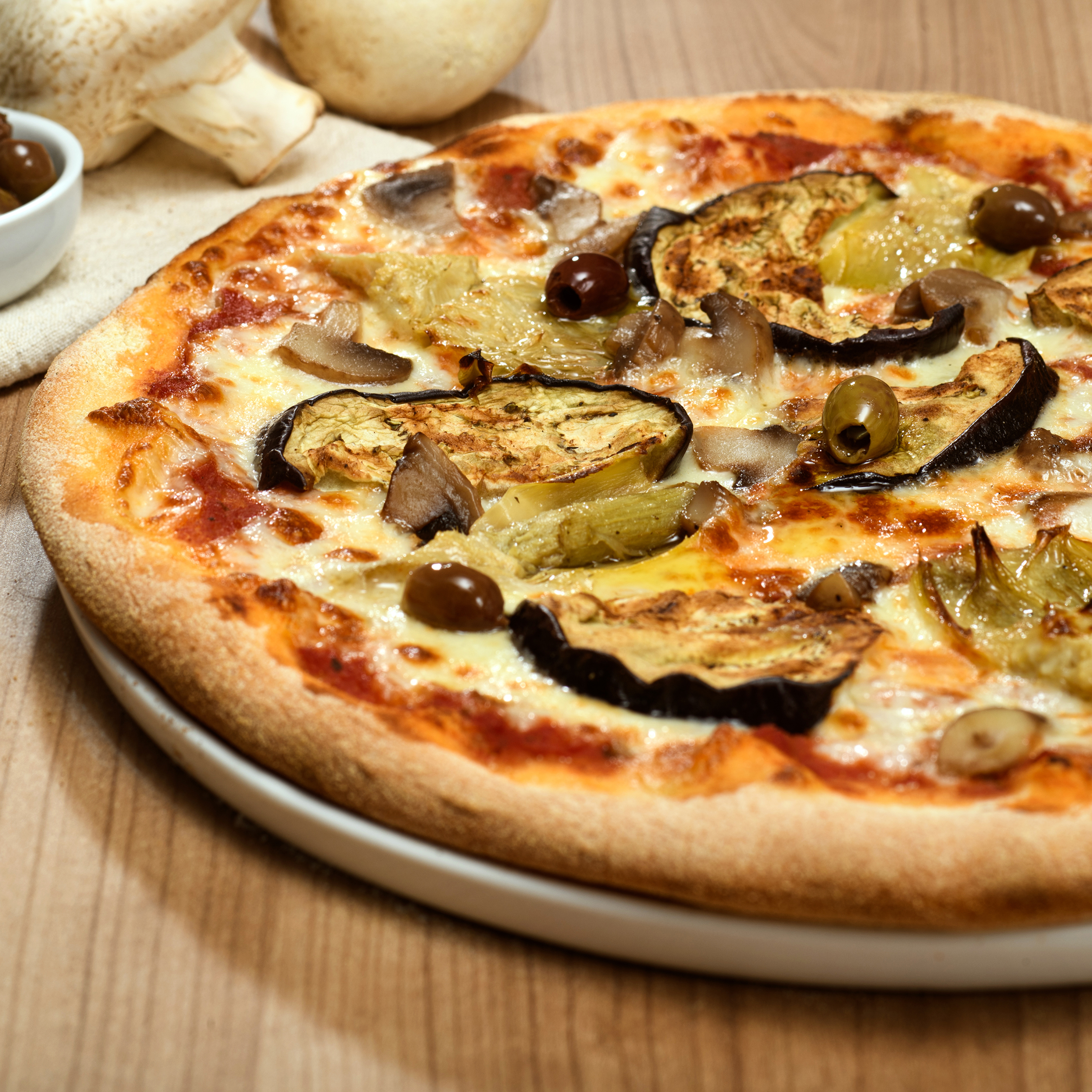 Pizza végétarienne avec aubergines grillées, champignons, cœurs d’artichauts, olives et mozzarella Fior di Latte
