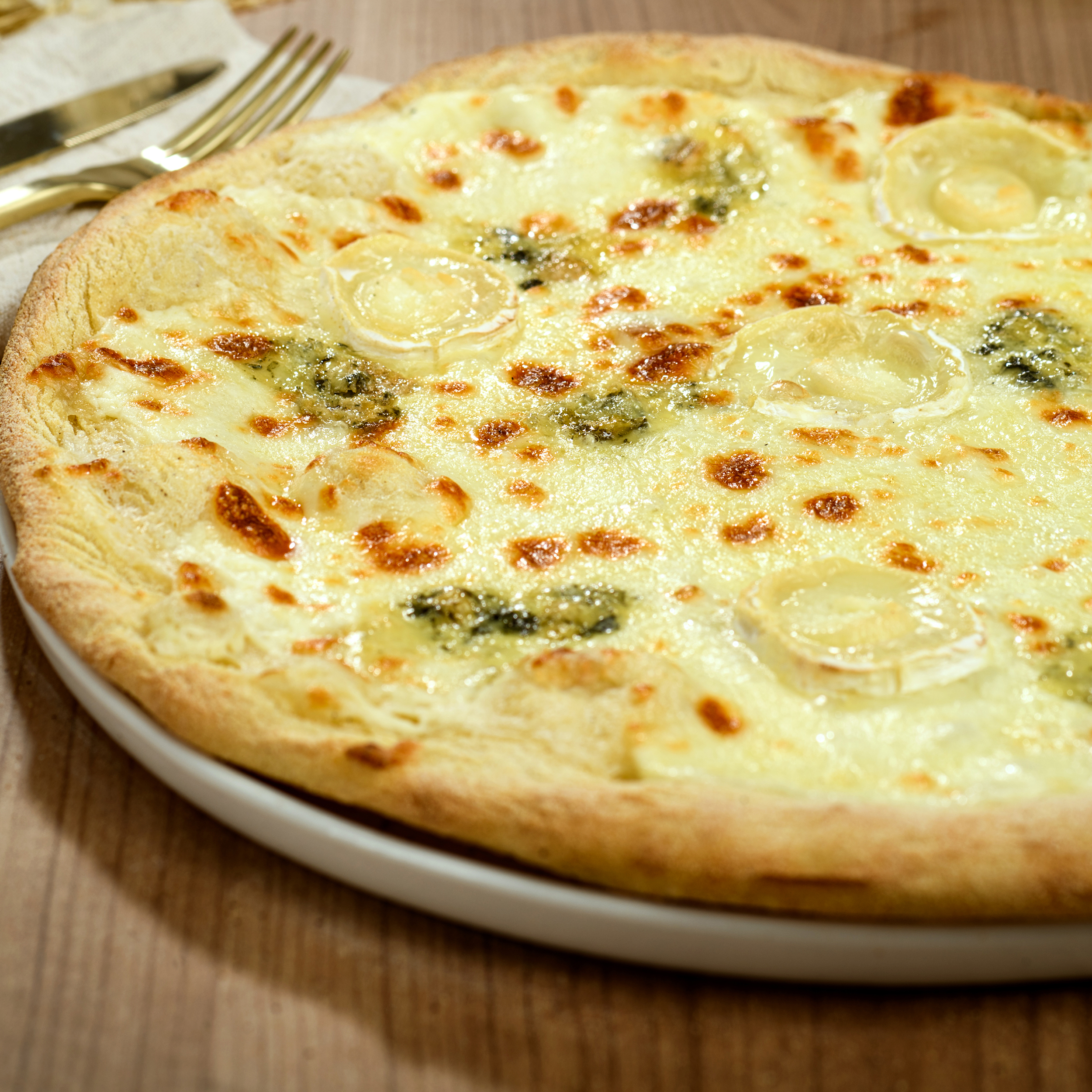 Pizza 4 fromages crème à emporter ou en livraison avec mozzarella, reblochon, chèvre et bleu AOP