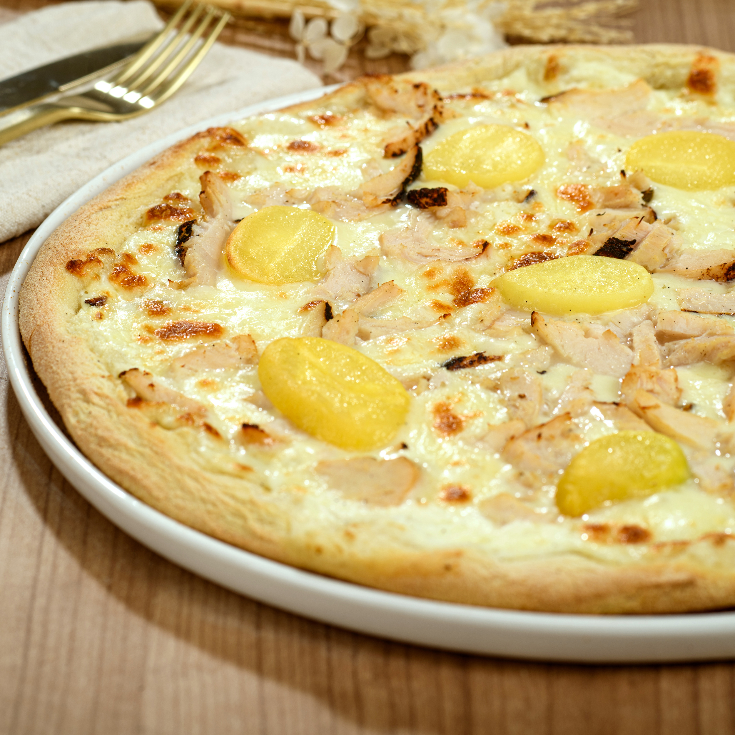 Pizza Pollo e Curry avec crème fraîche, mozzarella, morceaux de poulet, pommes de terre et sauce curry