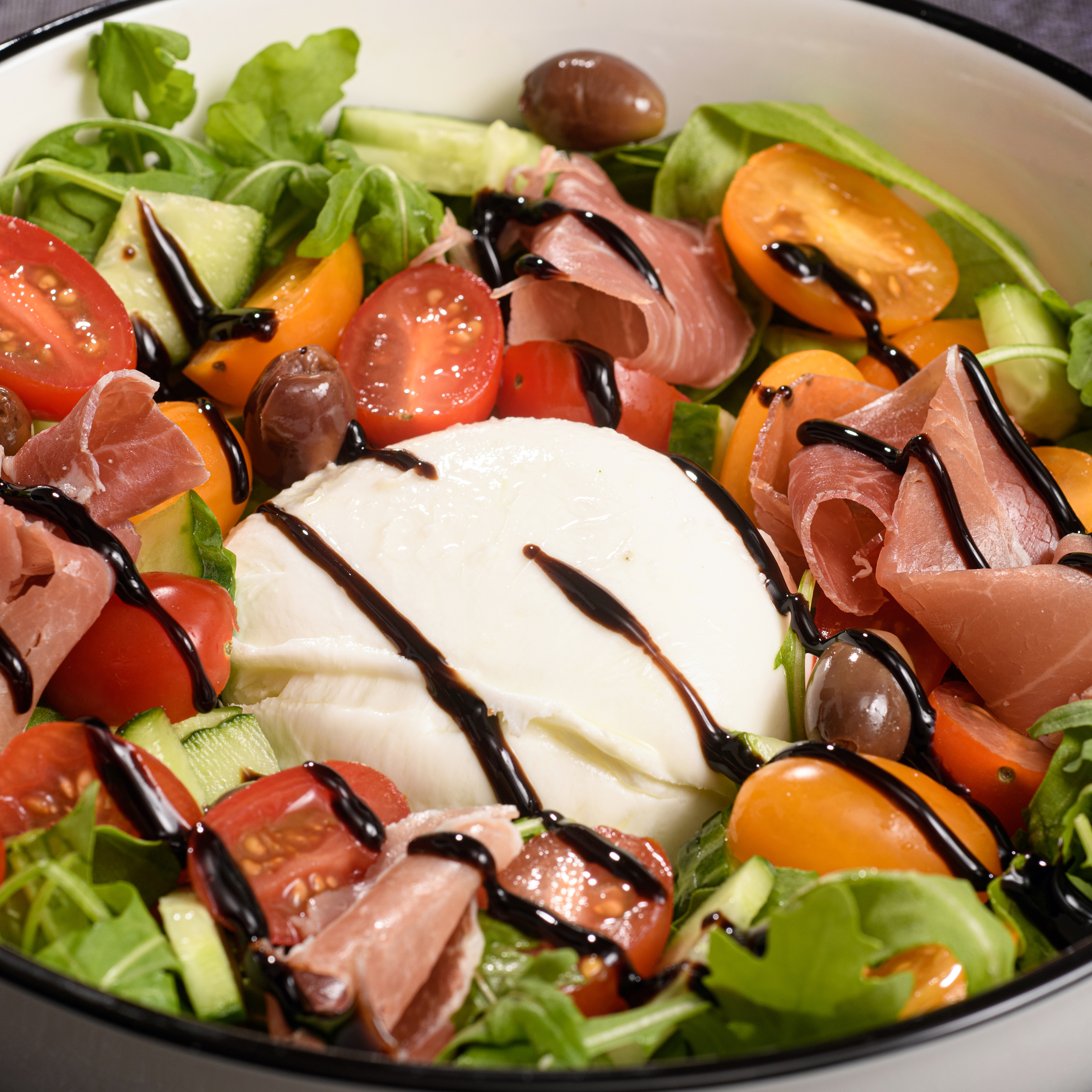 Salade italienne avec mozzarella di Bufala, tomates cerises, jambon de Parme et roquette – à emporter ou en livraison